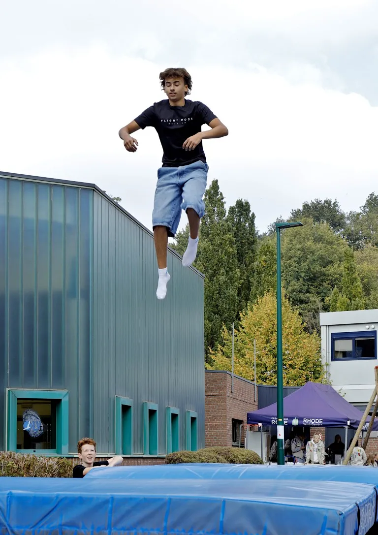 een jongen op de trampoline op de jaarmarkt van Rode